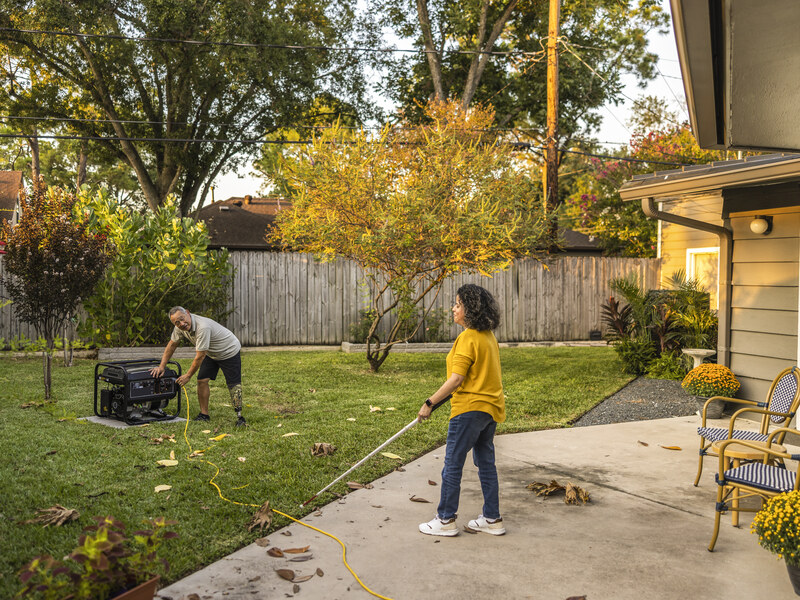 Portable generator set outdoors near a garage in daylight